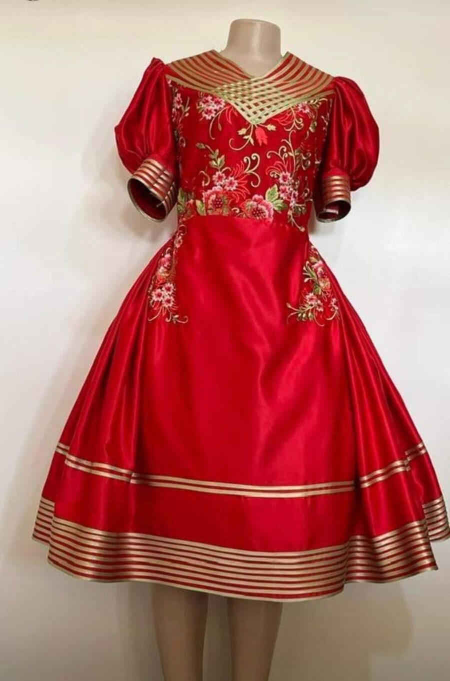 Misisi attire in red with gold trim, tailored by Clasian